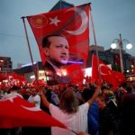 A supporter holds a flag depicting Turkish President Tayyip Erdogan during a pro-government demonstration in Ankara