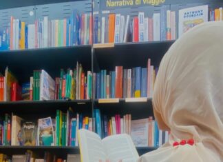 Laboratori di L2 alle superiori: Israt e Samia le prime diplomate studentessa di spalle davanti a libreria
